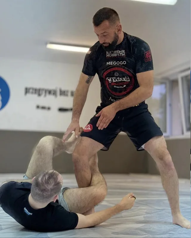 Arek kontroluje nogi partnera leżącego na macie