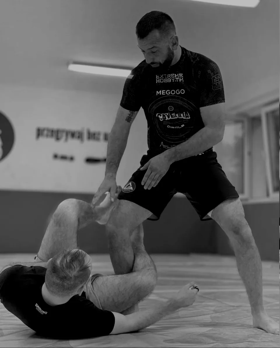Arek Jasnosz, trener BJJ w Tarnowie, kontroluje nogi partnera na macie